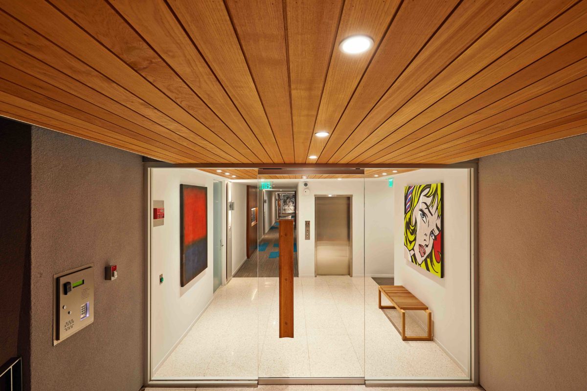 Apartment entry experience with wood clad ceiling and lights