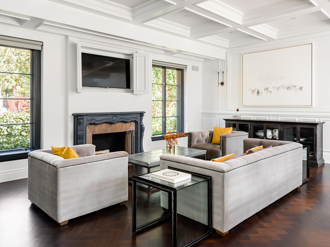 couches under elegant coffered ceiling and fireplace
