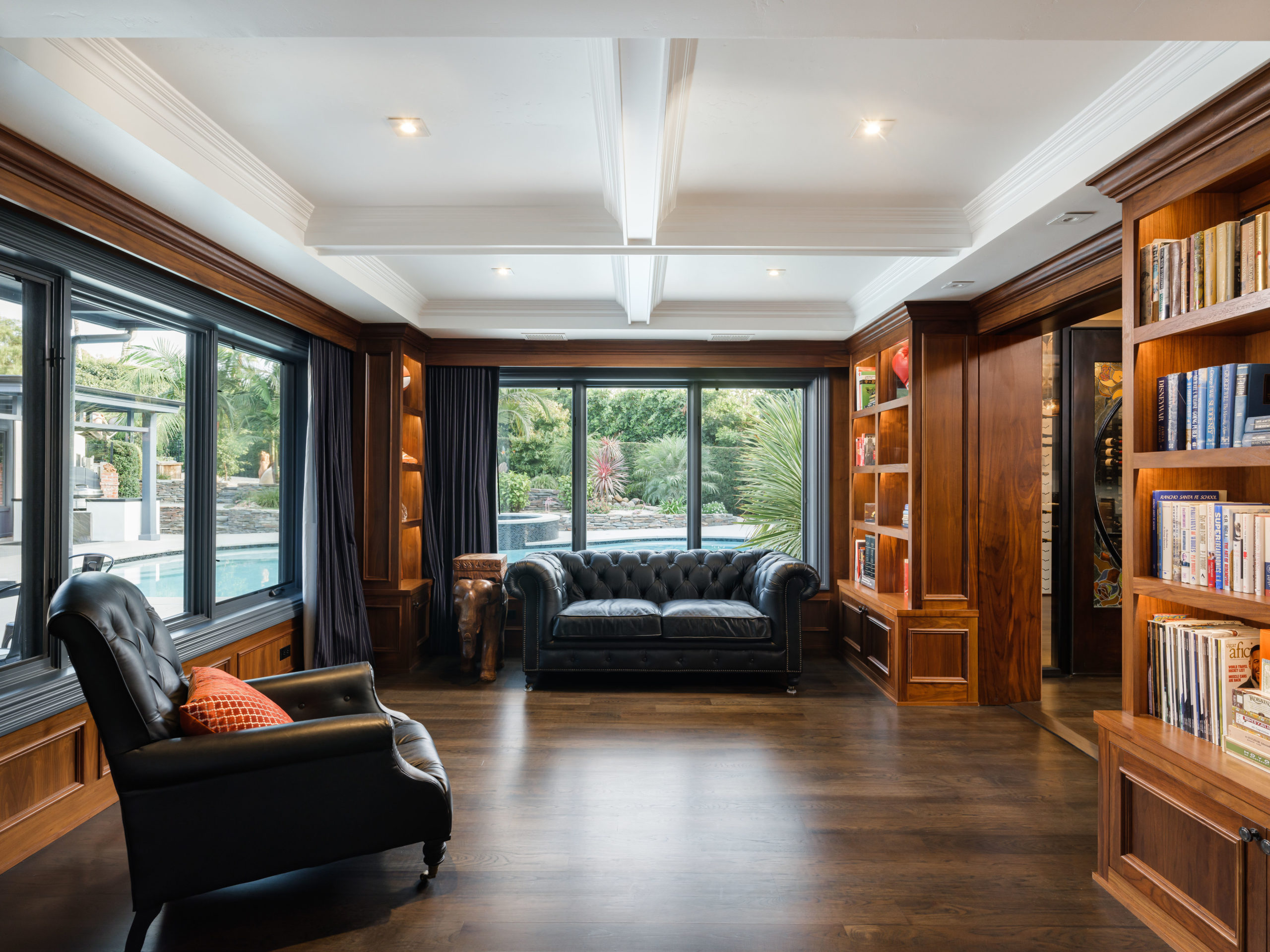library with wood paneling leather couches and coffered ceiling