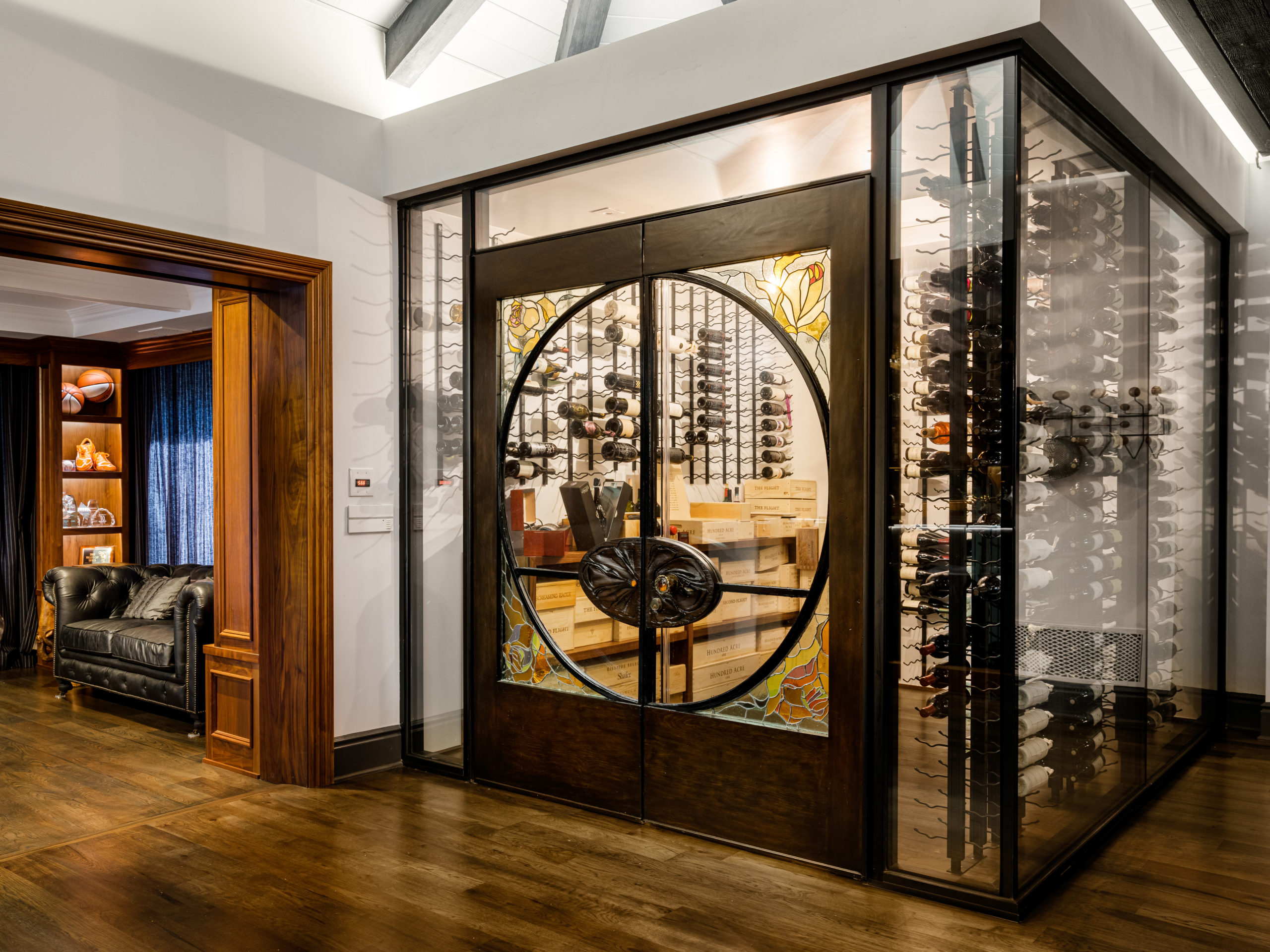 door to wine cellar with glass and wood floors