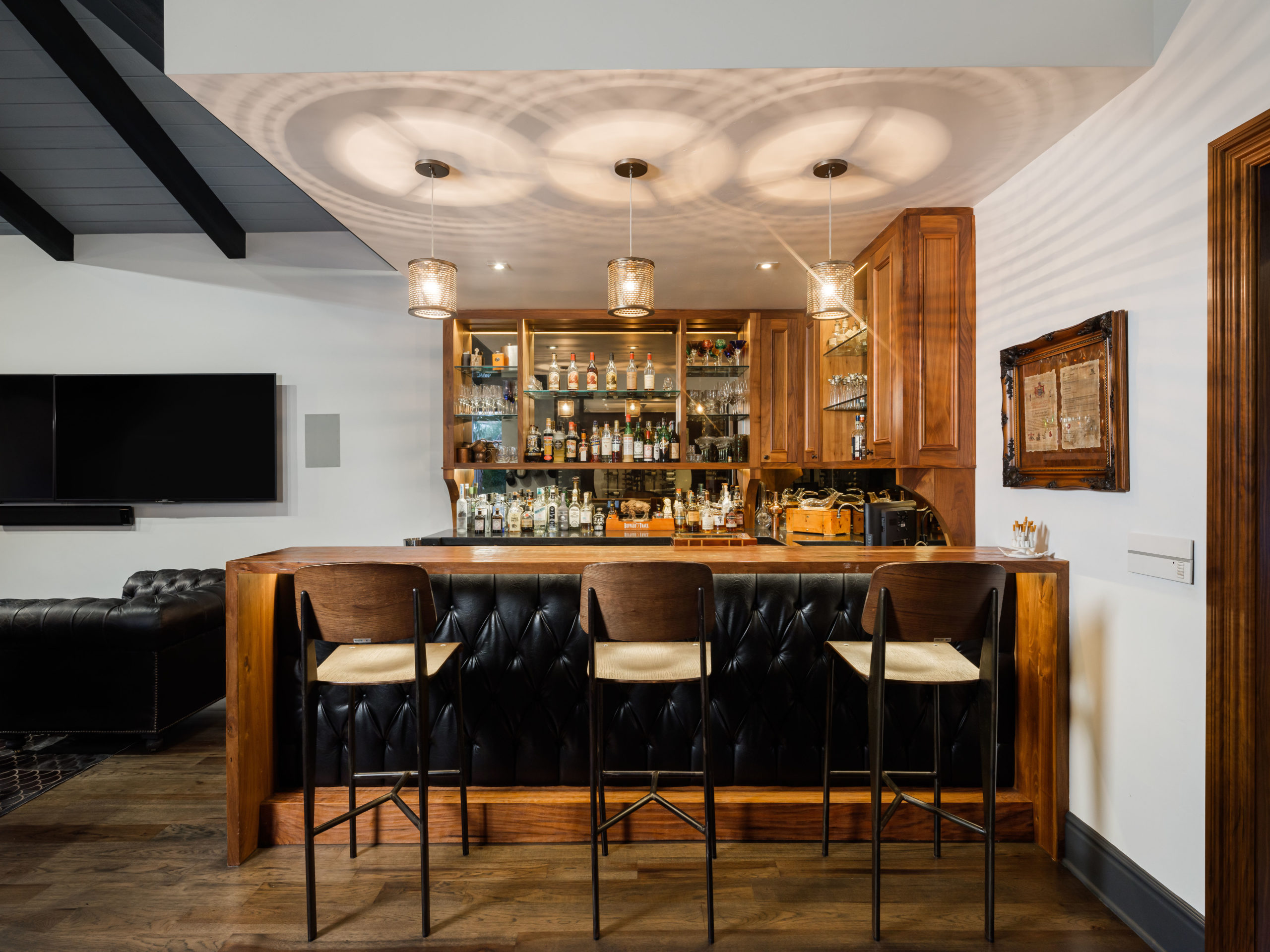 leather bar and barstools with hanging pendants