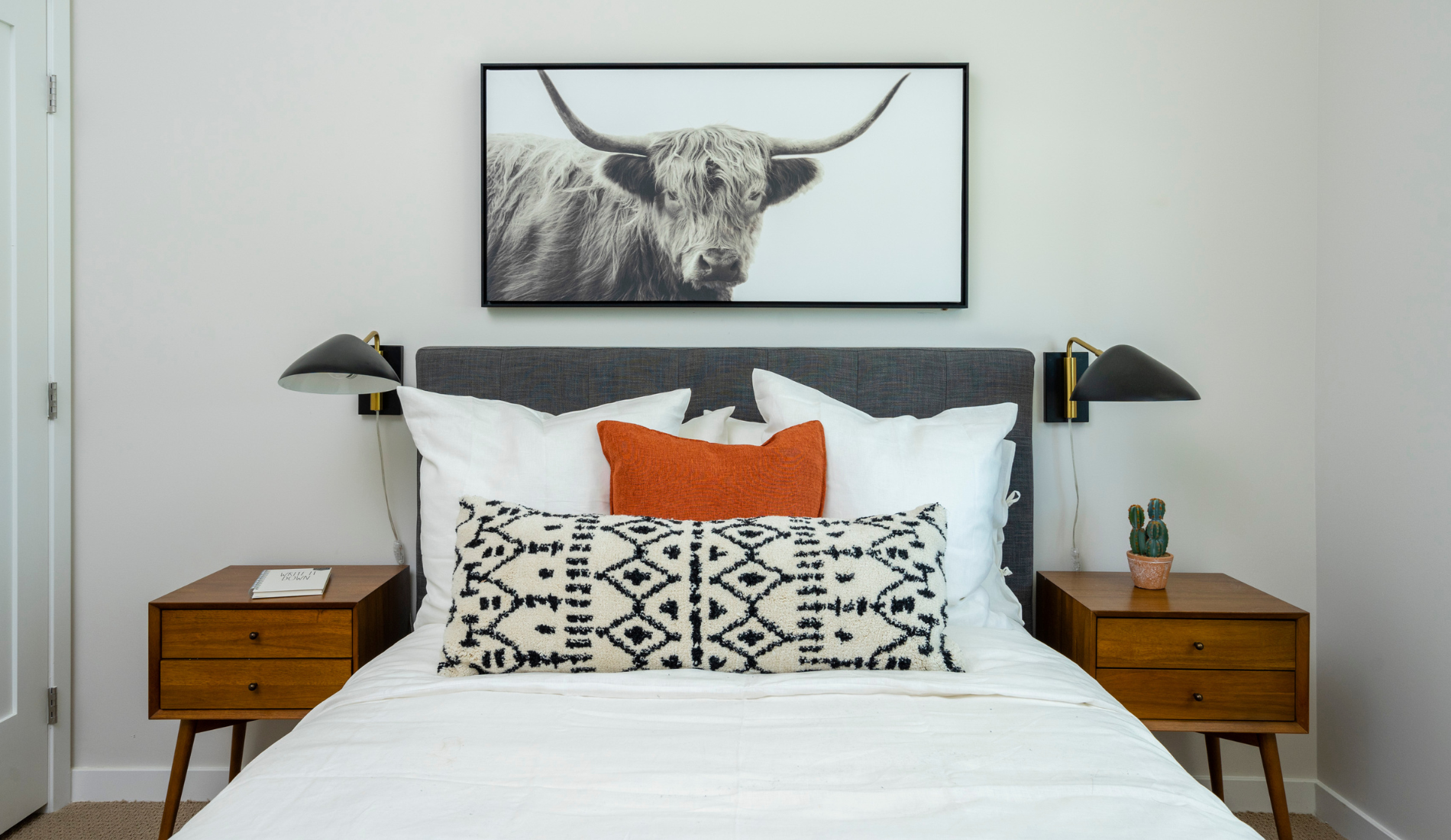 Palm Springs luxury modern resort interior design bedroom with pillows, photograph of bull on wall