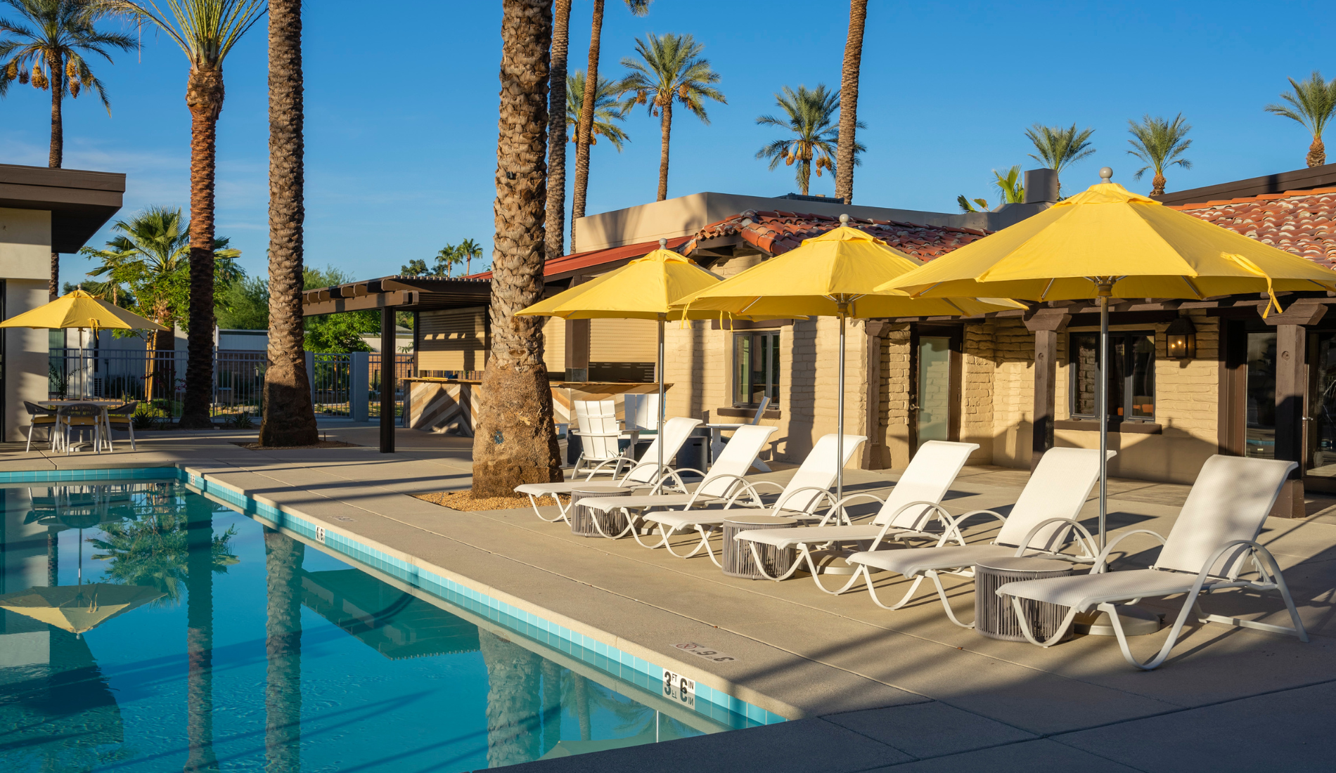 Palm Springs luxury resort pool with lounge chairs, umbrellas
