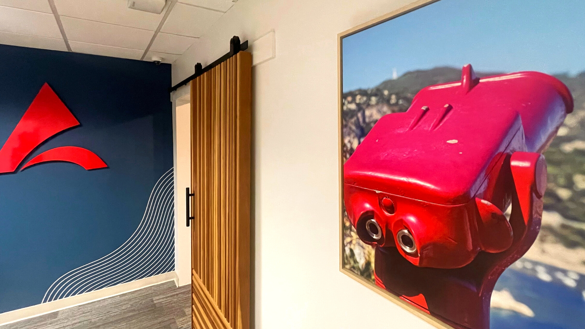 San Diego interior design of office space, blue wall, wood sliding door, red binocular photo framed on wall