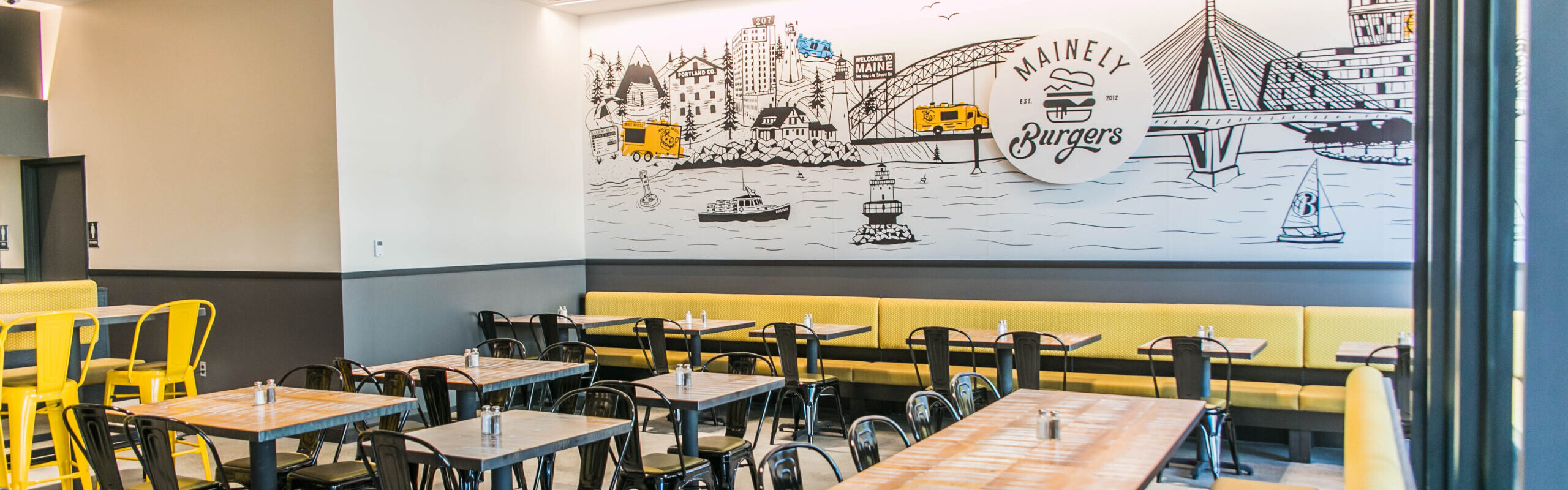 Fast Casual Burger restaurant and dining area with wall art, seating, chairs, and tables