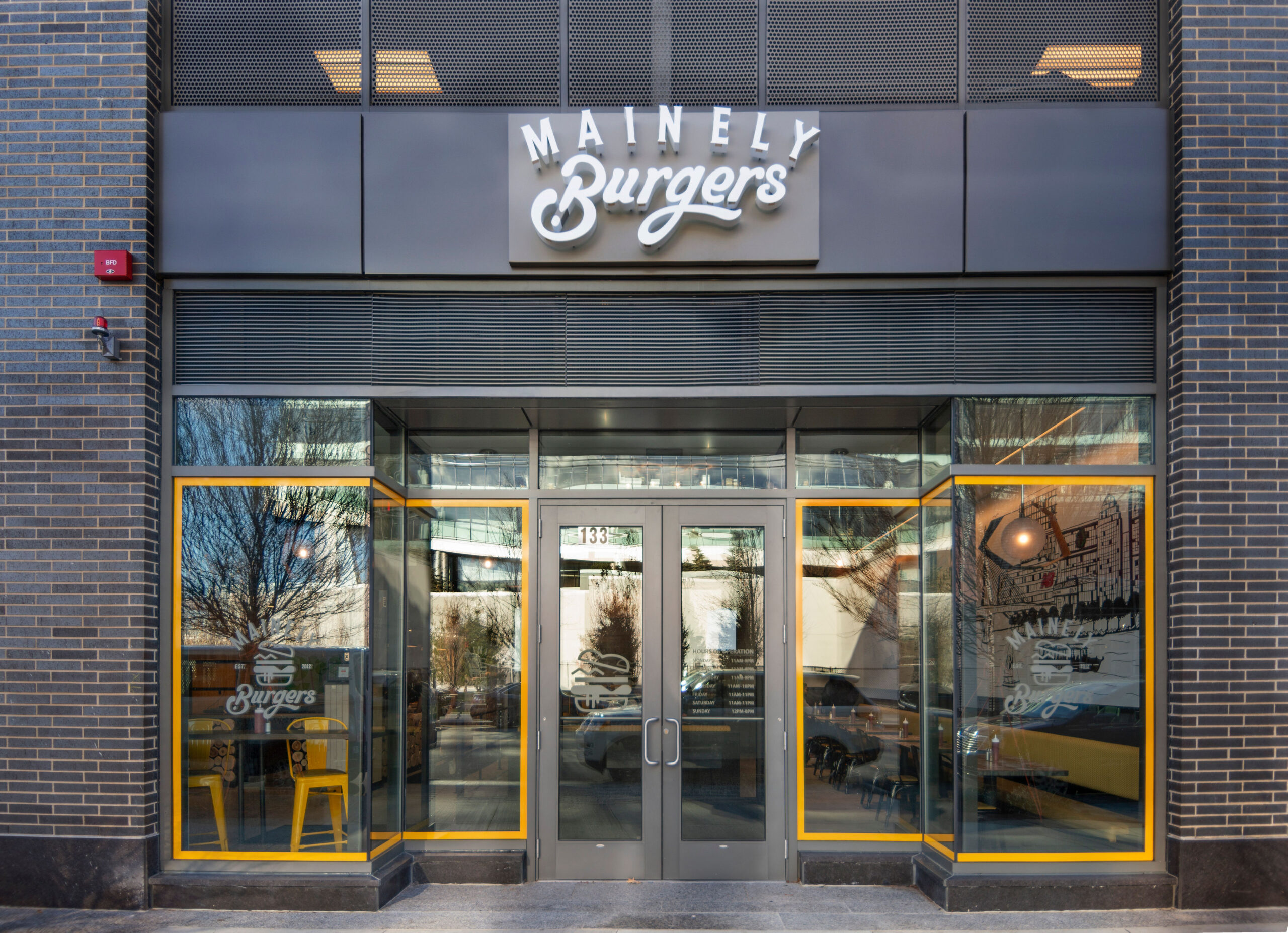 Fast Casual Exterior building design with brand logo, yellow detailing on doors, wood facade
